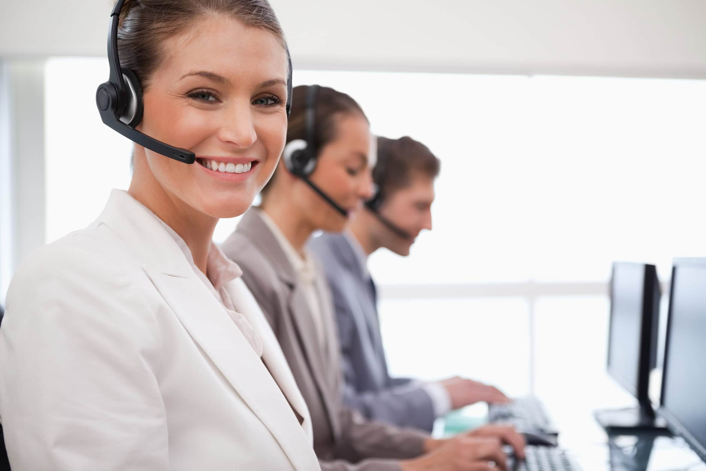 Smiling call center agent colleagues behind her